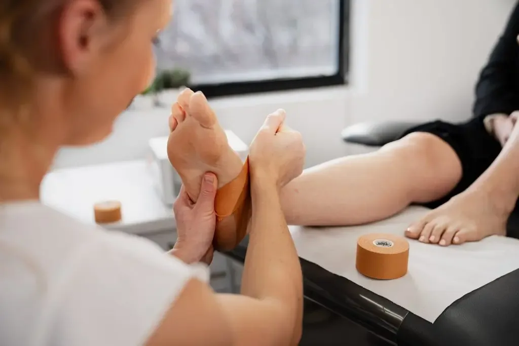 A podiatrist strapping a patient's foot with rigid tape